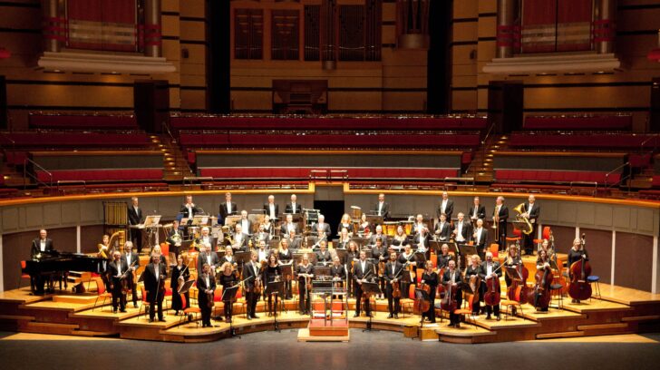 orchestra standing with instruments