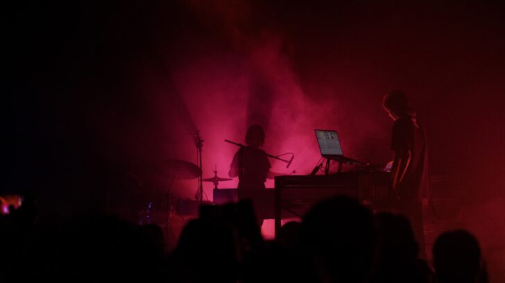 red lit and smoky room with DJ