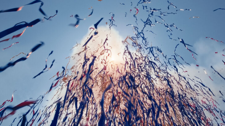 Looking up at sun through string confetti