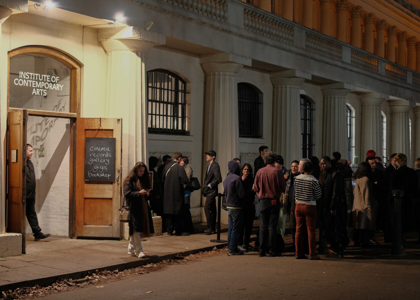 Crowd standing outside ICA on the Mall at night