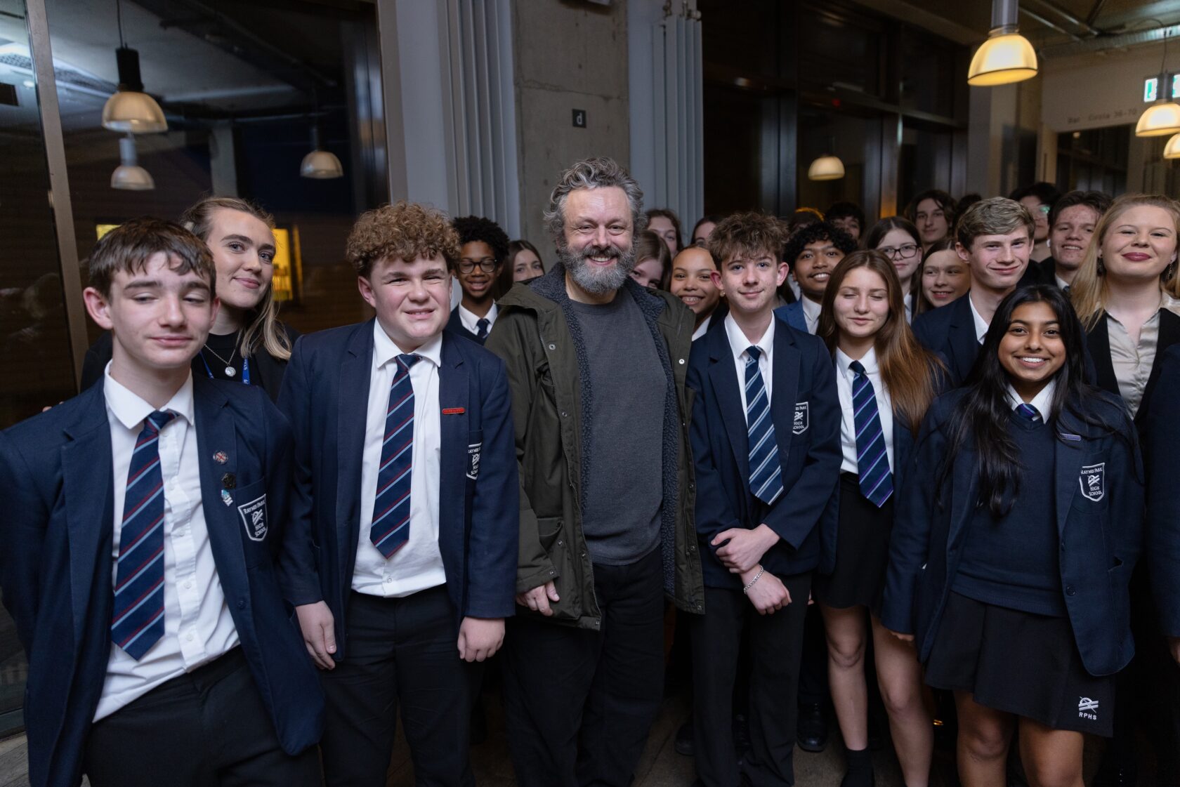 School children stand with Michael Sheen