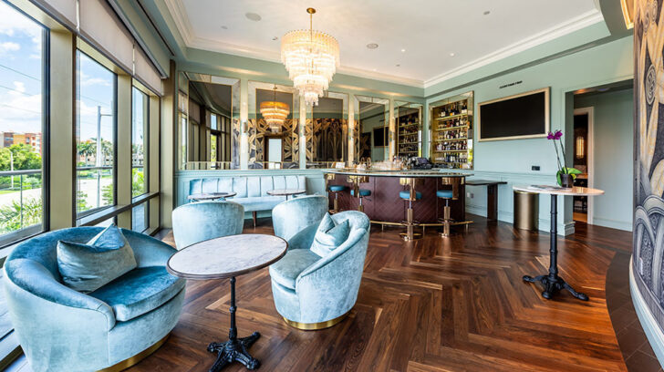 art deco room, with blue furnishings, mirrored walls and a bar