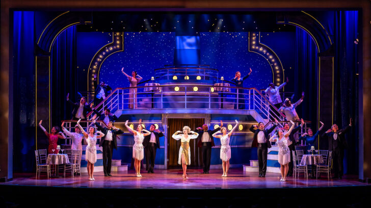 Stage filled with light and dancers in flapper style dresses and suits