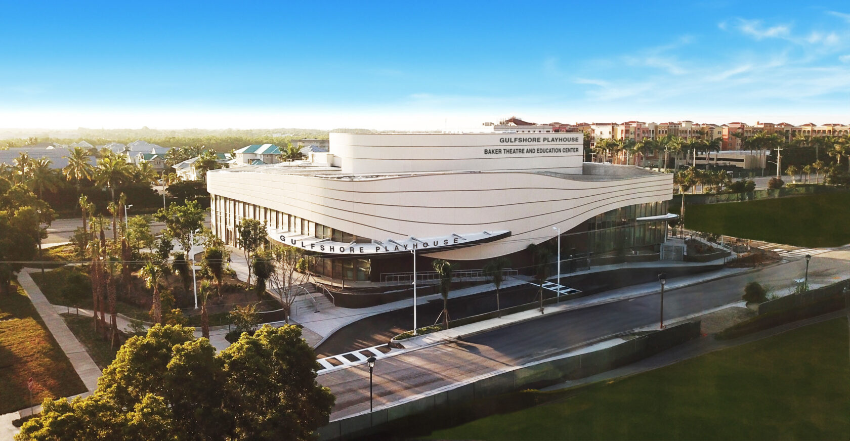 Theatre pictured above surrounded by palm trees and high-rise houses